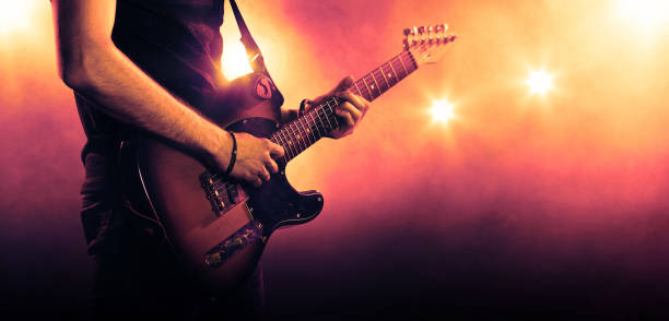 playing music/ Hand of a musician playing a guitar in backlit